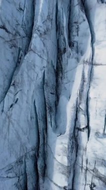 Aerial View, İzlanda 'daki bir Svinafellsjokull Buzulu üzerindeki derin yarıkların ve dokulu buzun karmaşık örüntülerini ortaya çıkarır. Dikey görüntüler