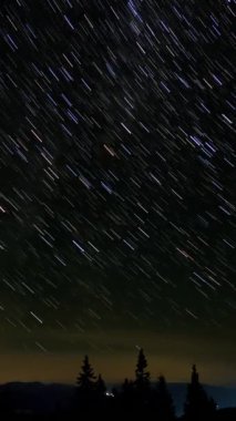 Gece gökyüzünde Yıldız 'ın zaman atlaması. Yıldızlar bir kutup yıldızının etrafında döner, dikey görüntüler