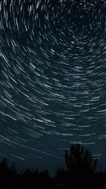Gece gökyüzünde Yıldız 'ın zaman atlaması. Yıldızlar bir kutup yıldızının etrafında döner, dikey görüntüler