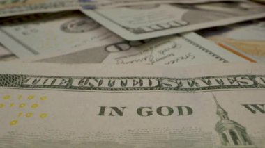 Banknotların ve güvenlik özelliklerinin detaylarını gösteren 100 dolarlık banknotların yakın plan çekimi..