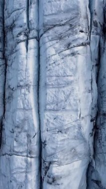 Aerial View, İzlanda 'daki bir Svinafellsjokull Buzulu üzerindeki derin yarıkların ve dokulu buzun karmaşık örüntülerini ortaya çıkarır. Dikey görüntüler