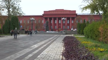 Ziyaretçiler, Kyiv 'deki Taras Shevchenko Ulusal Üniversitesi' nin güzel sahalarında geziniyor, keyifli bir günde canlı bahar çiçekleri ve tarihi mimarinin tadını çıkarıyorlar..