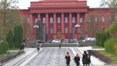 Kyiv 'deki Taras Shevchenko Ulusal Üniversitesi' nde canlı bir mezuniyet töreni düzenlenirken, cübbeli öğrenciler kutlama yapıyor. Üniversitenin ana binası kırmızıya boyandı.