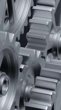 Yakından bakıldığında, mekanik tasarımın karmaşıklığını ve mühendisliğini vurgulayan bir dizi birbirine kenetlenmiş metal vites görülüyor. dikey görüntüler