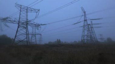 Sakin ve sisli bir sabahın ortasında, sakin bir manzaranın üzerinde yükselen elektrik hatları endüstriyel ve doğal elementlerin harmanlanmış saf güzelliğini gözler önüne seriyor..