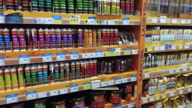 KYIV, UKRAINE - DEC 22, 2024: Sayısız tüp ve yapıştırıcı ve boya kapları parlak bir hırdavat mağazası koridorundaki raflarda düzenli olarak çeşitli renk ve tiplerde sergilenmektedir.