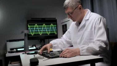 Elektronik Mühendisi bir dizüstünü tamir ediyor. Arka planda çeşitli elektronik araçlar ve dalga formu gösteren bir monitör, teşhis ve sorun çözme önerileri yer alıyor