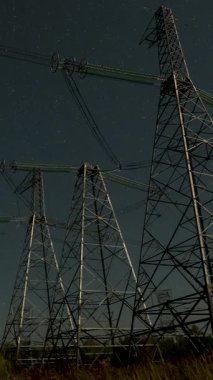 Yıldızlı Gece Gökyüzüne Karşı Elektrik Güç Hattının zaman aşımı, yüksek voltajlı iletim kuleleri yıldız dolu bir gökyüzü altında siluet, gece altyapısı, dikey görüntüler