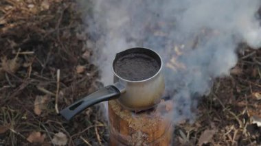 İsveç Meşalesi 'nde Kamp Ateşi Kahvesi, İsveç meşalesi ocağında sıcak kahve, orman macerası sırasında ormanda yükselen duman.