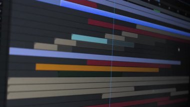 Yaratıcı projeler için video içeriğini düzenleme ve düzenleme sürecini gösteren çeşitli renkli klipleri gösteren dijital düzenleme zaman çizgisinin ayrıntılı bir görünümü.