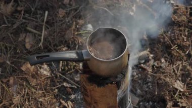 İsveç Meşalesi 'nde Kamp Ateşi Kahvesi, İsveç meşalesi ocağında sıcak kahve, orman macerası sırasında ormanda yükselen duman.