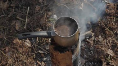 İsveç Meşalesi 'nde Kamp Ateşi Kahvesi, İsveç meşalesi ocağında sıcak kahve, orman macerası sırasında ormanda yükselen duman.