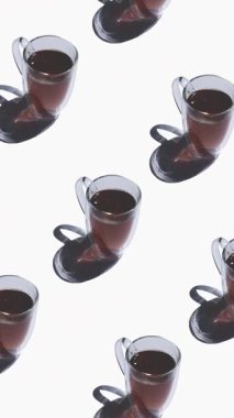 Beyaz arka planda bir sürü çay fincanı olan desen. Sıcak içecekli çay fincanları farklı yönlere hareket eder. dikey görüntüler