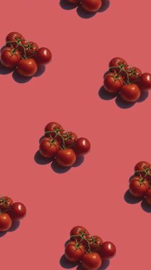 Kırmızı arkaplanda bir sürü domates deseni var. Domatesler farklı yönlere hareket eder. dikey görüntüler