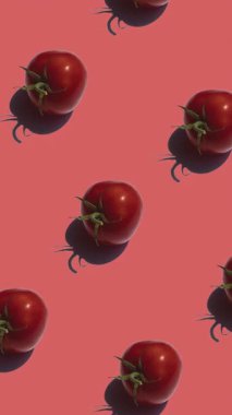 Kırmızı arkaplanda bir sürü domates deseni var. Domatesler farklı yönlere hareket eder, dikey görüntüler