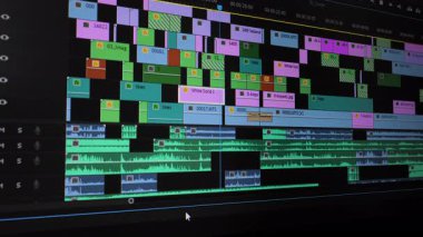Düzenleme yazılımında ses ve video katmanları ile çoklu iz zaman çizgisi, istiflenmiş parçaları ve ses dalgaboylarını gösteren video düzenleme arayüzünün ayrıntılı görünümü