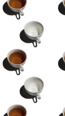 Beyaz arka planda bir sürü çay fincanı ve boş fincanı olan desen. Sıcak içecekli çay fincanları farklı yönlere hareket eder. dikey görüntüler