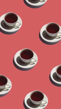 Yalnız çaydanlığı olan bir kalıp ve kırmızı arka planda bir sürü çay animasyonu. Çay fincanları farklı yönlere hareket eder. dikey görüntüler