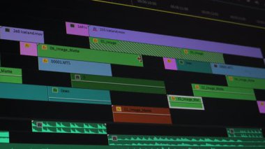 Detaylı çok kanallı video düzenleme zaman çizelgesinin ses katmanları, renkli arayüzler, katmanlı klipler, efektler ve senkronize dalga formlarını post-editleme sırasında gösterir