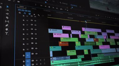 Düzenleme yazılımında ses ve video katmanları ile çoklu iz zaman çizgisi, istiflenmiş parçaları ve ses dalgaboylarını gösteren video düzenleme arayüzünün ayrıntılı görünümü