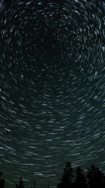 Gece gökyüzünde Yıldız 'ın zaman atlaması. Yıldızlar bir kutup yıldızının etrafında döner, dikey görüntüler