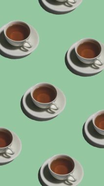 Bir sürü çay fincanı ve çay tabağı desenleri yeşil arka planda canlandırılmış. Sıcak içeceği olan çay fincanları farklı yönlere, dikey görüntülere yönelir.