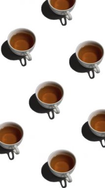 Beyaz arka planda bir sürü çay fincanı olan desen. Sıcak içeceği olan çay fincanları farklı yönlere, dikey görüntülere yönelir.