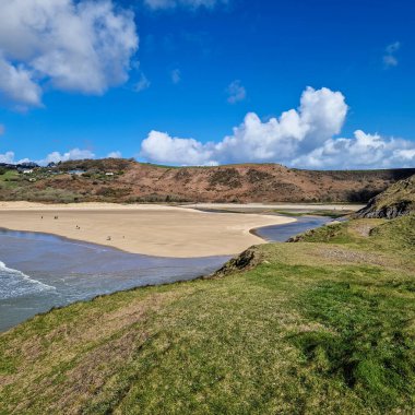 Arka planda görünen üç uçurum keskin açıları ve engebeli dokularıyla sahneye dram katıyor. Körfezin sakin ve berrak suları sörf, yüzme ya da huzurlu bir günün tadını çıkarmak için mükemmel bir zemin sağlar.