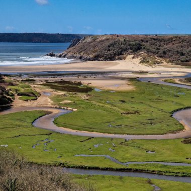 Arka planda görünen üç uçurum keskin açıları ve engebeli dokularıyla sahneye dram katıyor. Körfezin sakin ve berrak suları sörf, yüzme ya da huzurlu bir günün tadını çıkarmak için mükemmel bir zemin sağlar.