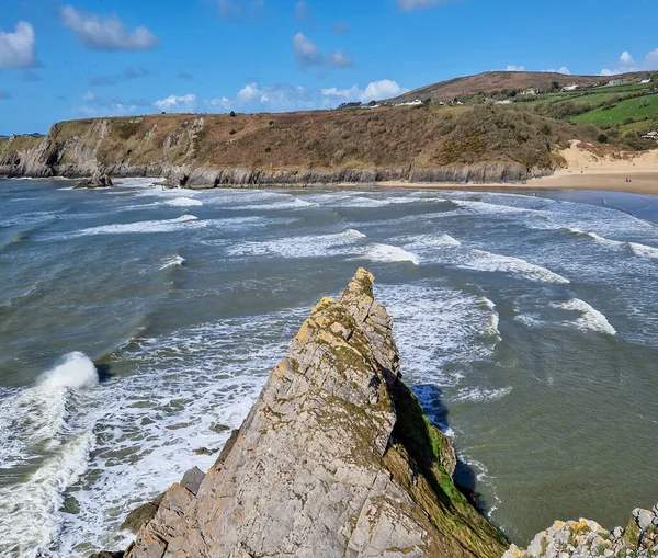 stock image The three cliffs are visible in the background, with their sharp angles and rugged textures adding an element of drama to the scene. The calm, clear waters of the bay provide a perfect backdrop for surfing, swimming, or simply enjoying a peaceful day