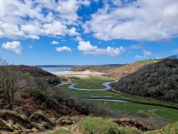 stock image The three cliffs are visible in the background, with their sharp angles and rugged textures adding an element of drama to the scene. The calm, clear waters of the bay provide a perfect backdrop for surfing, swimming, or simply enjoying a peaceful day