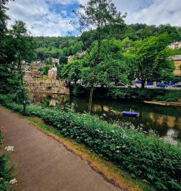Matlock 'un büyüleyici çekiciliğini keşfedin, ikonik High Tor sahne aldıkça. Resmedilmeye değer bir kasabada, Yüksek Tor 'un yüksek mevcudiyeti göze çarpıyor. Engebeli uçurumları Derwent Nehri 'nin yumuşak akışına karşı durmaktadır.. 