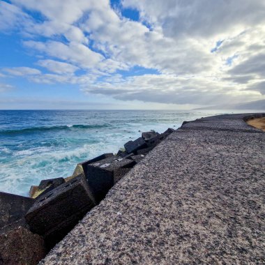 Şafak sökerken, Puerto de la Cruz sabah güneşinin yumuşak kucaklamasına uyanır. Şehir, hala gecenin kalıntılarıyla sarılı, ışığın ilk ışıklarıyla parıldamaya başlıyor. Sokaklar, binalar ve sular S 'nin yumuşak pastel tonlarını yansıtıyor.