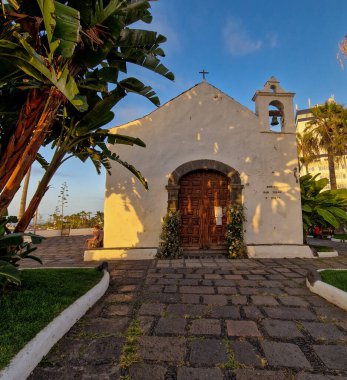 Şafak sökerken, Puerto de la Cruz sabah güneşinin yumuşak kucaklamasına uyanır. Şehir, hala gecenin kalıntılarıyla sarılı, ışığın ilk ışıklarıyla parıldamaya başlıyor. Sokaklar, binalar ve sular S 'nin yumuşak pastel tonlarını yansıtıyor.