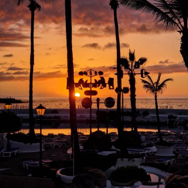 Güneş ufkun altına batarken Puerto de la Cruz büyüleyici bir altın renkle yıkanır. Şehrin silueti alevli arka plana karşı dimdik duruyor. Huzur ve güzellik anı yaratıyor..