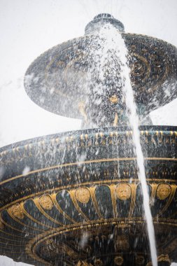 Place de la Concorde 'daki çeşme Paris' te kar altında faaliyet gösteriyor.