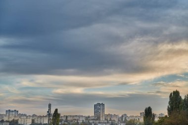  Tüylü bulutlar akşam ışığında mavi gökyüzünde şehrin üzerinde