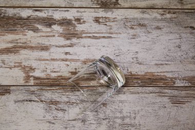 An overturned empty glass on a worn countertop. Problems with alcohol, loneliness, and alcohol clipart