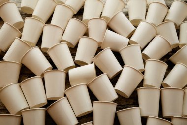 Kâğıt bardaklar sıcak güneş ışığında yere saçılmış.