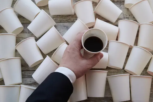 Bir iş adamı elinde yarım kalmış bir kahve bardağını masanın üzerine koyuyor. Zor karar