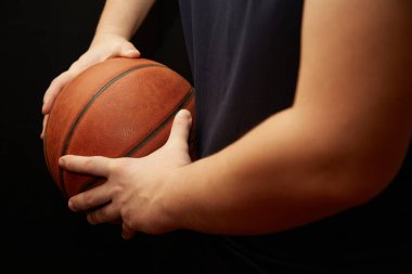 Bir basketbol oyuncusunun elleri topu kenarda tutar, basketbolda topu korur, basketbol antrenmanında