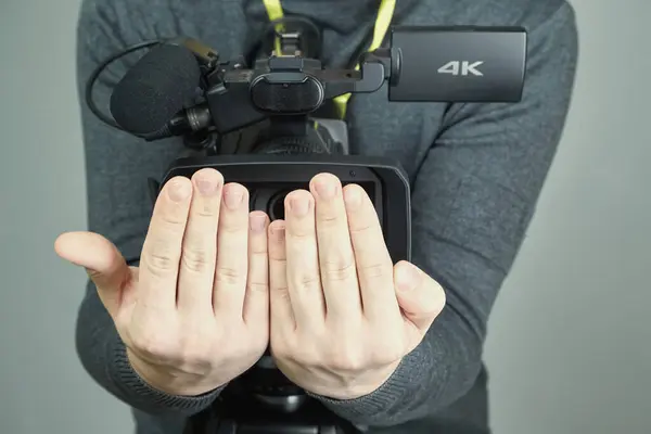 Kameranın objektifini tutan iki el, kapalı avuçlardan gözetleme, korkakça, video çekmenin yasaklanması için değil.