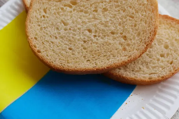 Dilimlenmiş ekmek Ukrayna bayrağında bir tabakta yatıyor, Ukrayna ekmeği satışı, Ukrayna ekmeği ve tahılla ilgili sorunlar