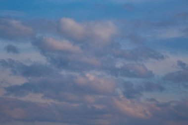 Batan güneşin ışığında bulutlar, gökyüzündeki bulutların üzerinde akşam ışığı