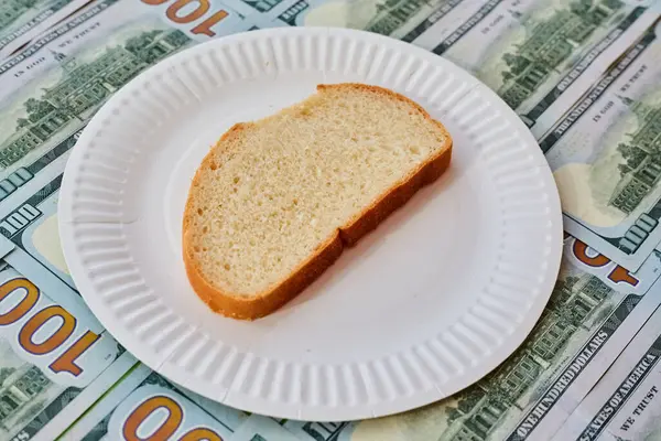 Dolar banknotları, artan gıda fiyatları, finansal açlık, yetersiz beslenme, sıkı diyet, yetersiz istihkak, beyaz tabakta bir parça ekmek.