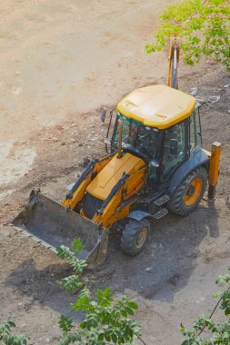 İnşaat alanındaki buldozer yeşil ağaç dalları, inşaat yerleri inşaat alanları inşaat alanında buldozer, dikey çekim..