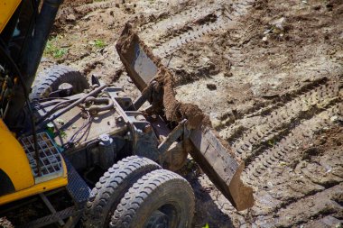 Toprak işlerinde çalışan buldozer kovası, buldozerle yapılan inşaat çalışmaları, buldozer çalışmaları, buldozerle hazırlanan ana yol tuvali.