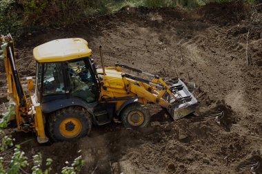 İnşaat sahasında zemini yerle bir eden buldozer, buldozer çalışması, inşaat sahasında zemini yerle bir eden buldozer, buldozer toprak çalışmaları.