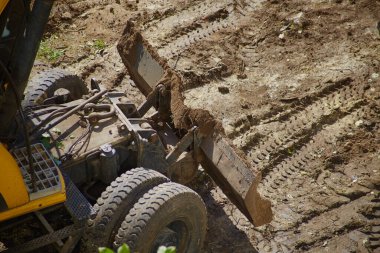 Buldozer inşaat sahasında zemini dümdüz ediyor, buldozer toprağı işliyor.
