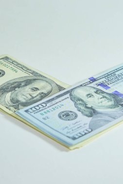 Yığınla yüz dolarlık banknotlar üst üste yatar, dikey çekim.